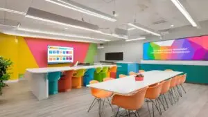 Colorful school collaboration space with education digital signage displaying company updates and team achievements.